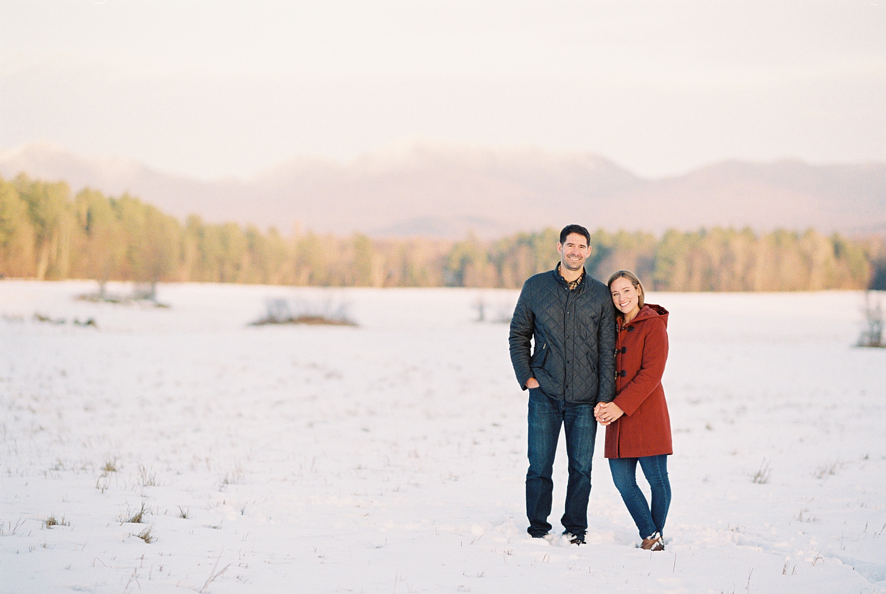 Lake_Placid_Winter_Engagement_Photos_AS_0005 couple standing in snowy field in lake placid ny
