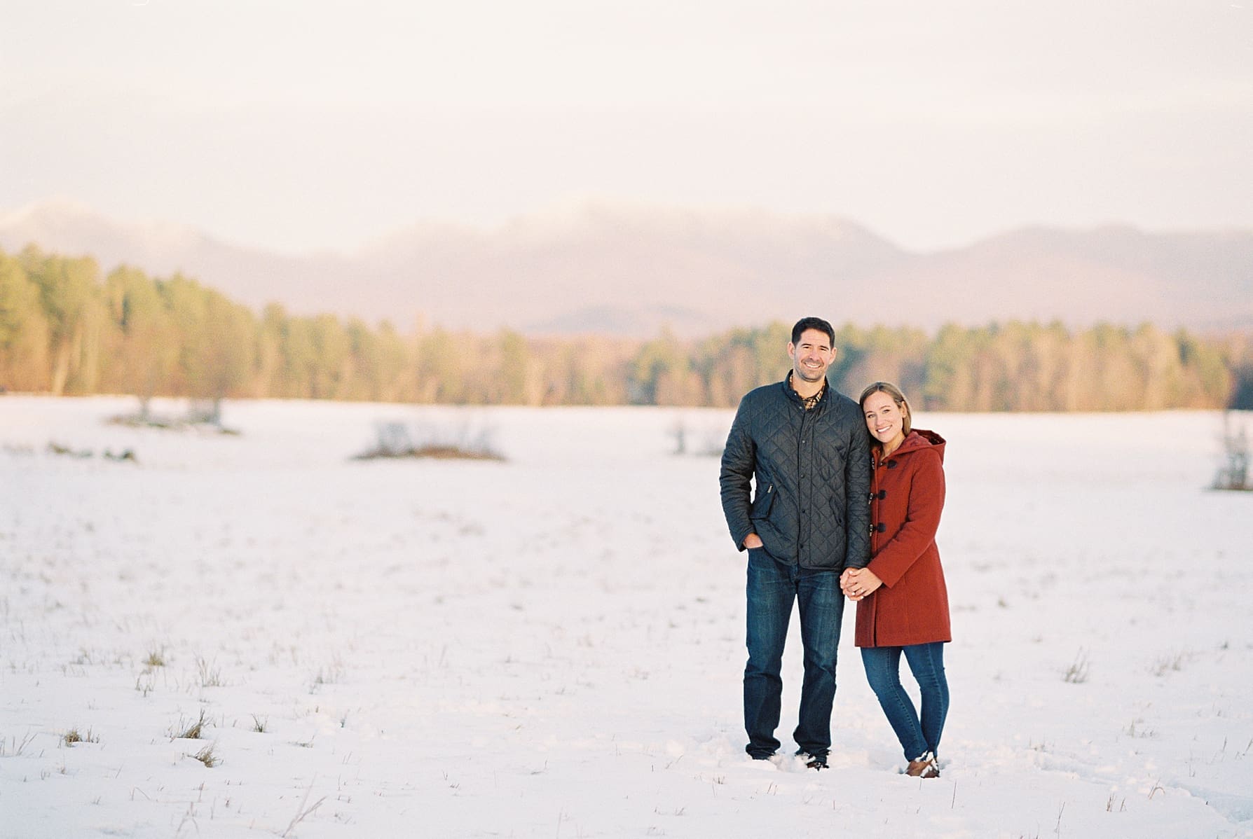 Lake_Placid_Winter_Engagement_Photos_AS_0005 couple standing in snowy field in lake placid ny