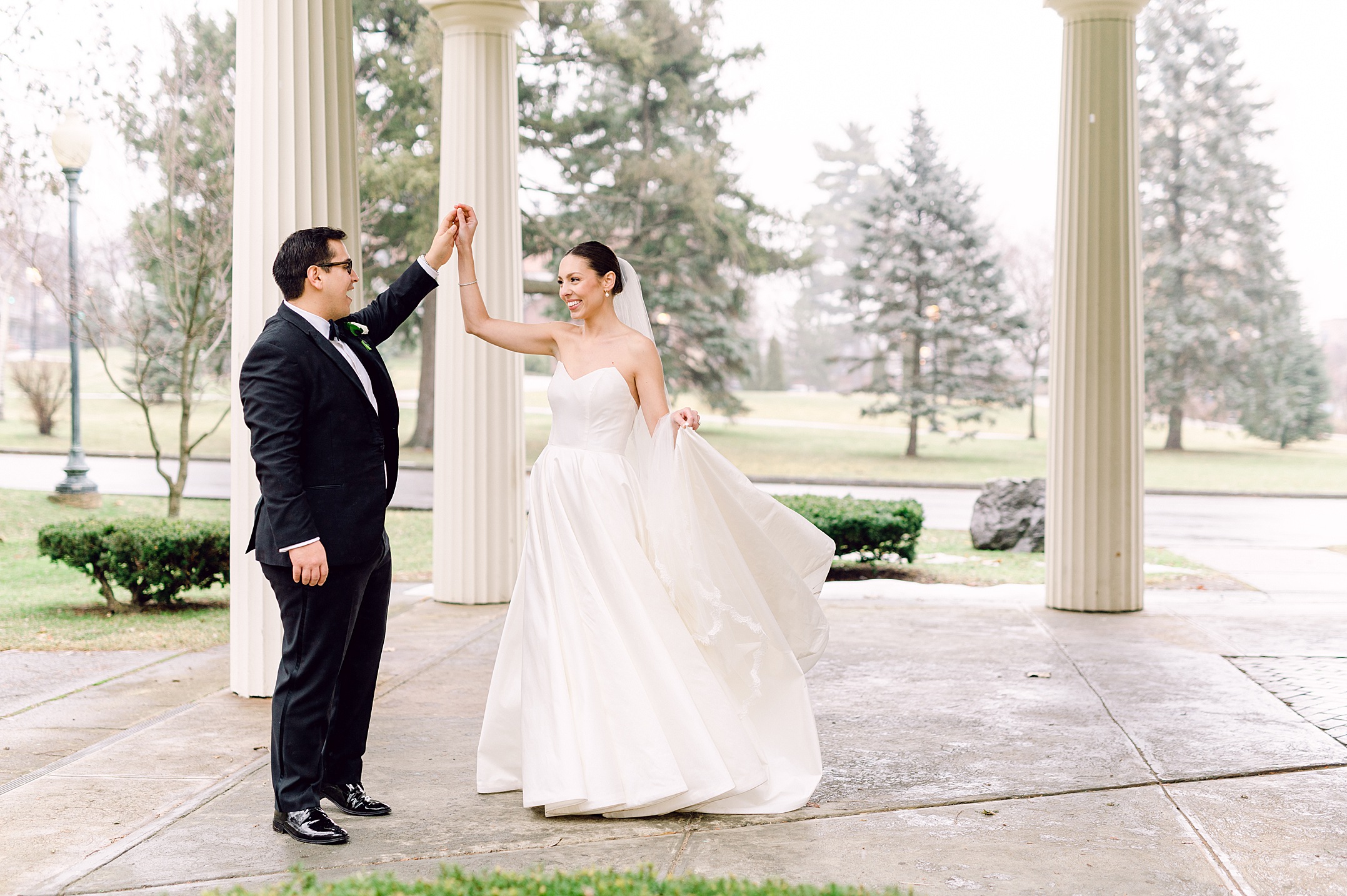 bride laughing at her husband during portraits on their wedding day at the Canfield Casino in Saratoga Springs